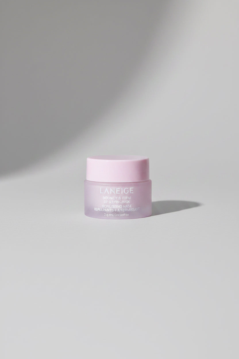 LANEIGE Clear Gel cream jar with a pale pink lid and frosted white body, placed on a textured dark blue surface with a visible shadow.
