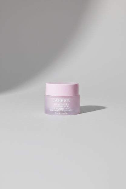 LANEIGE Clear Gel cream jar with a pale pink lid and frosted white body, placed on a textured dark blue surface with a visible shadow.